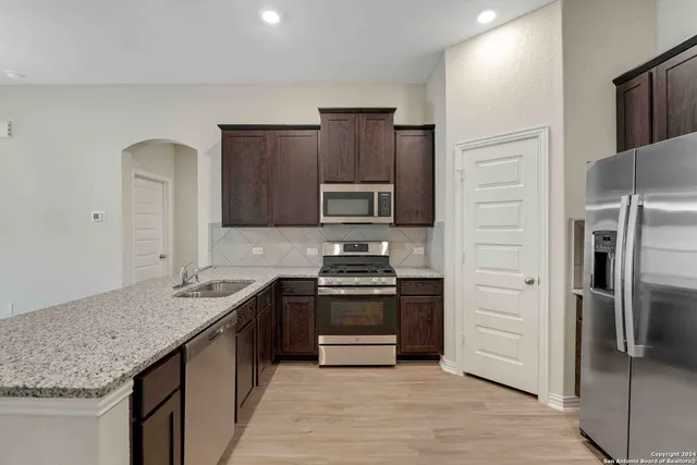 a kitchen with stainless steel appliances granite countertop a sink stove and refrigerator