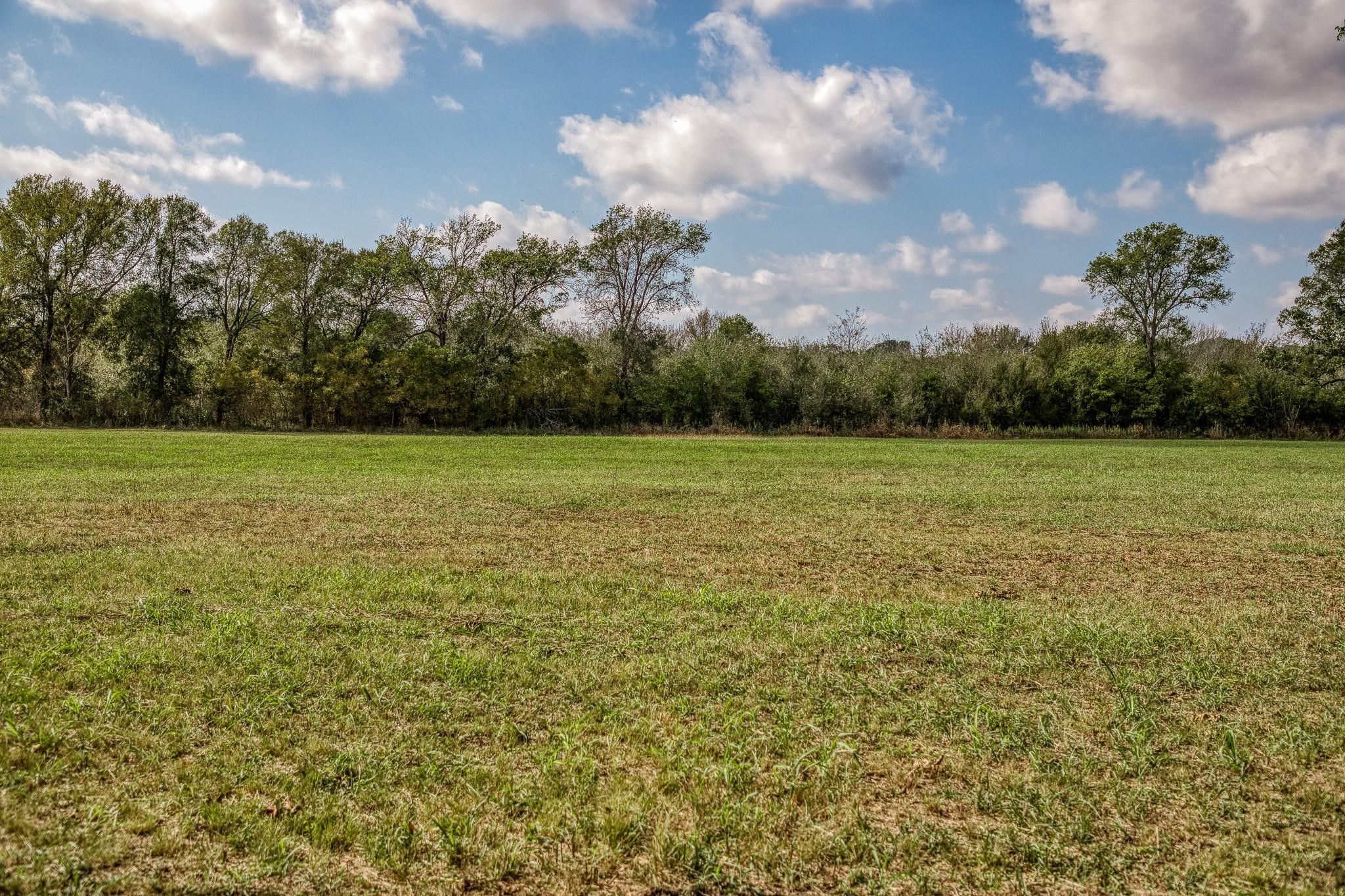 0 Sun Oil Road Brenham, TX 77833 - Photo 11 of 26 a view of a green field with wooden fence
