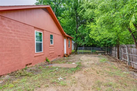 a backyard of a house with plants and tree
