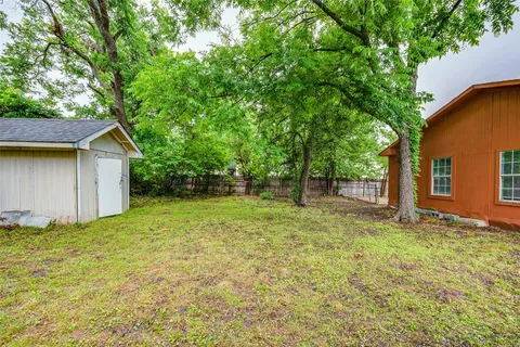 a view of a backyard with large trees
