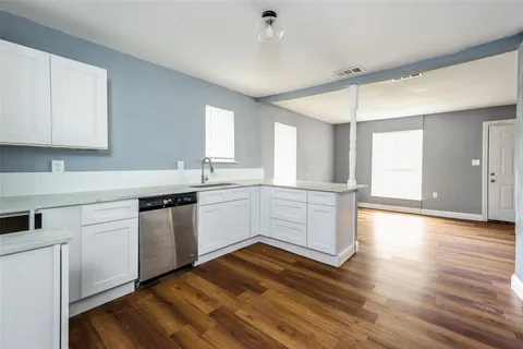 a kitchen with granite countertop white cabinets and white appliances