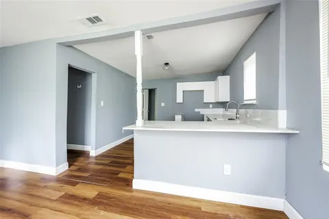 a view of a kitchen with wooden floor and a sink