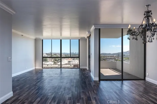 a view of a room with wooden floor and a floor to ceiling window