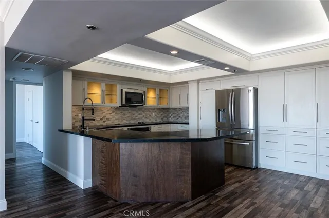 a kitchen with stainless steel appliances granite countertop a refrigerator and a stove