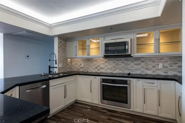 a kitchen with granite countertop cabinets stainless steel appliances and a sink