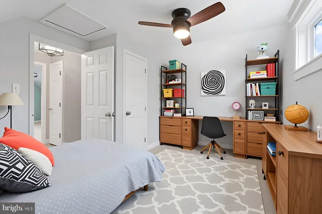 an empty room with windows and fan