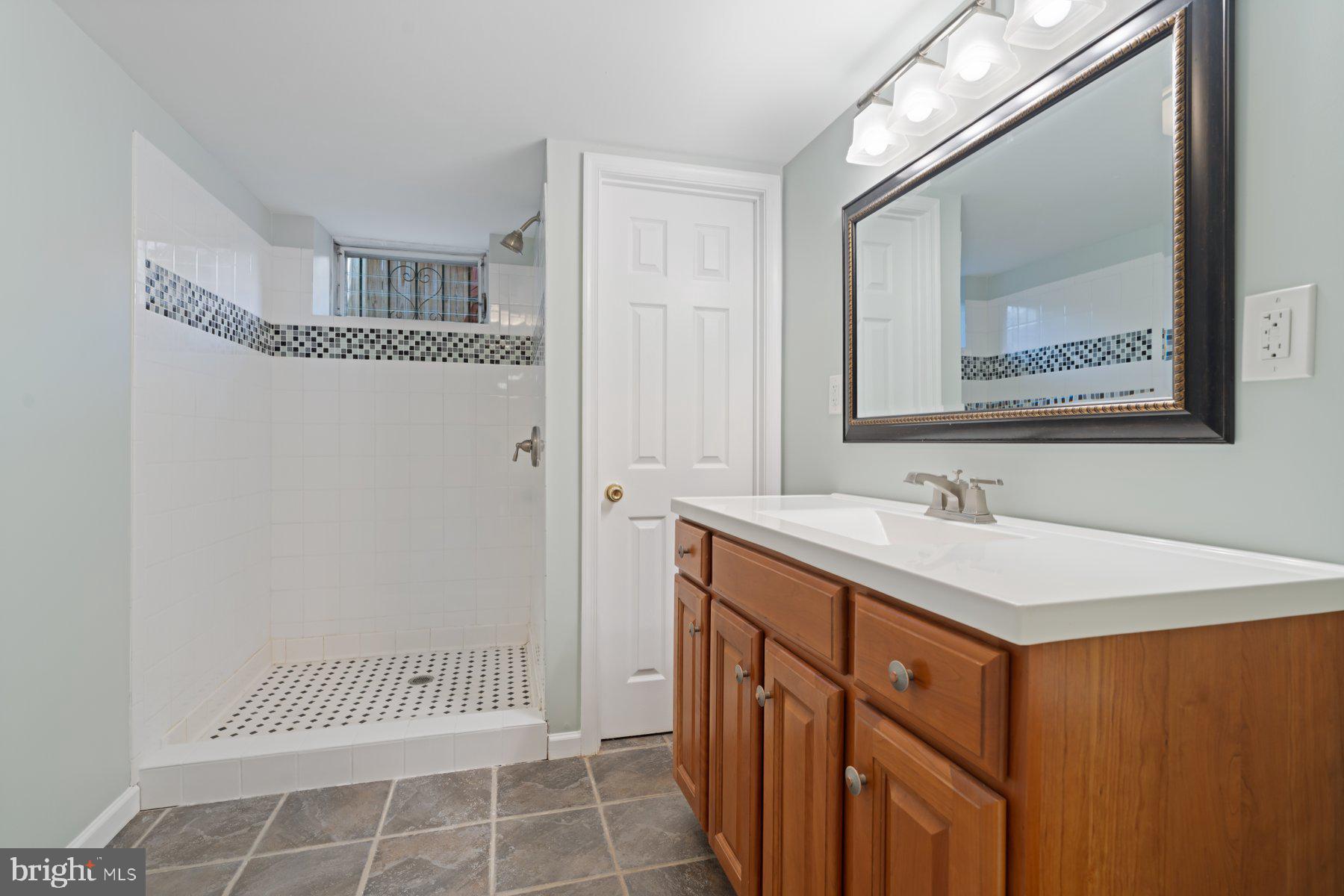 27 Edgemoor Road Lutherville-Timonium, MD 21093 - Photo 29 of 42 a bathroom with a sink a mirror and a shower