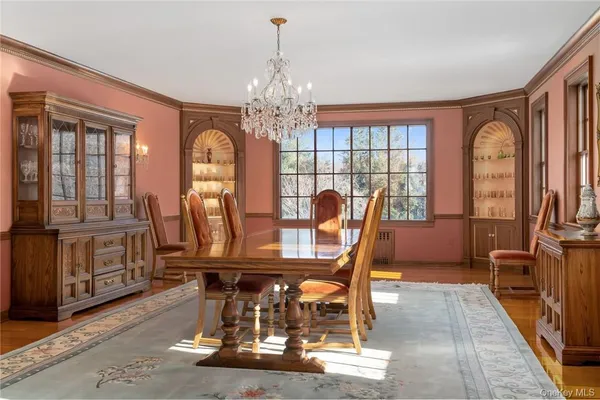 a dining room with furniture a chandelier and wooden floor