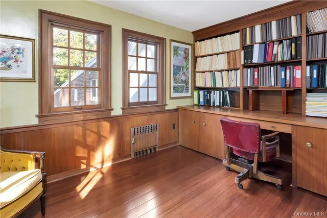 a view of a workspace with furniture and a window