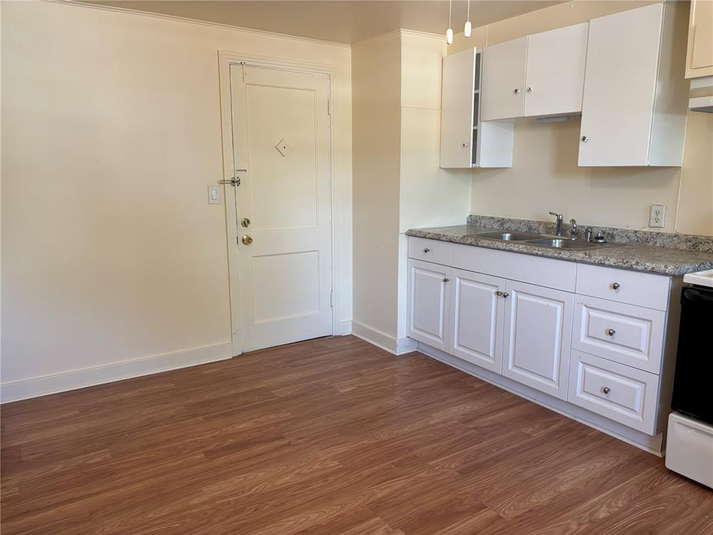 507 Cleveland Avenue Southwest, Unit 2 Largo, FL 33770 - Photo 8 of 20 a kitchen with granite countertop white cabinets and wooden floor