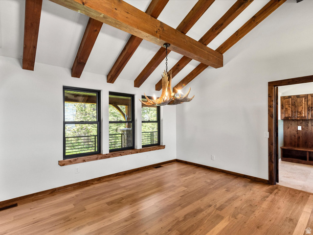 1225 Old Oregon Road Soda Springs, ID 83276 - Photo 16 of 67 Vaulted ceiling with exposed wood beams, wood-finish flooring, and antler-style chandelier