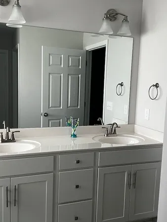 a bathroom with a double vanity sink and a mirror