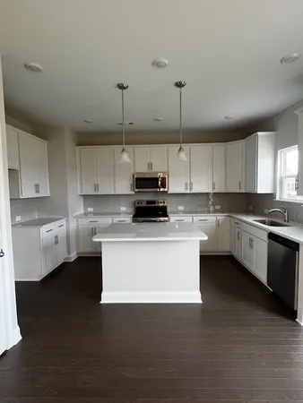 a kitchen with stainless steel appliances granite countertop a sink a stove and a refrigerator