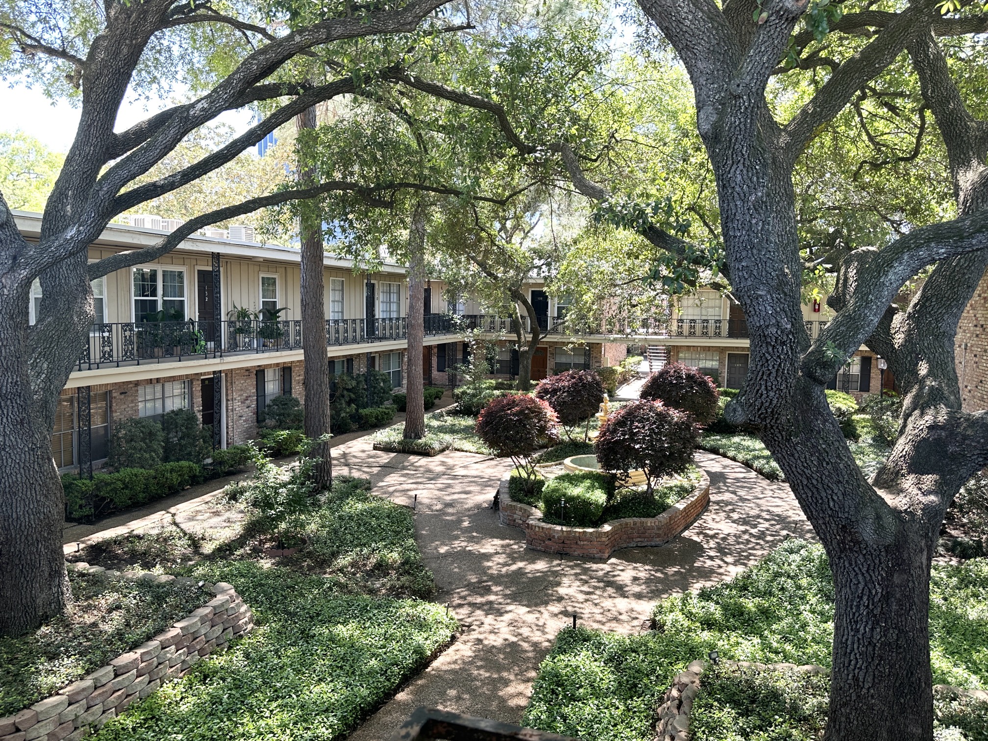 3224 Timmons Lane, Unit 154 Houston, TX 77027 - Photo 18 of 21 a front view of a house with a yard and a garden