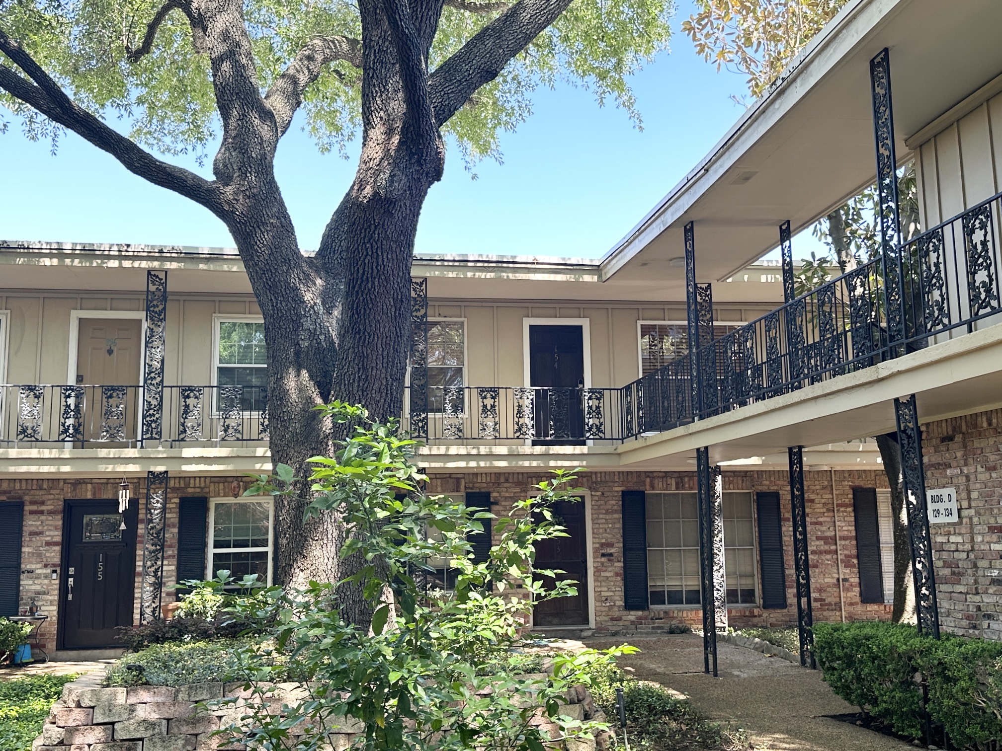3224 Timmons Lane, Unit 154 Houston, TX 77027 - Photo 20 of 21 a front view of a house with plants and large trees
