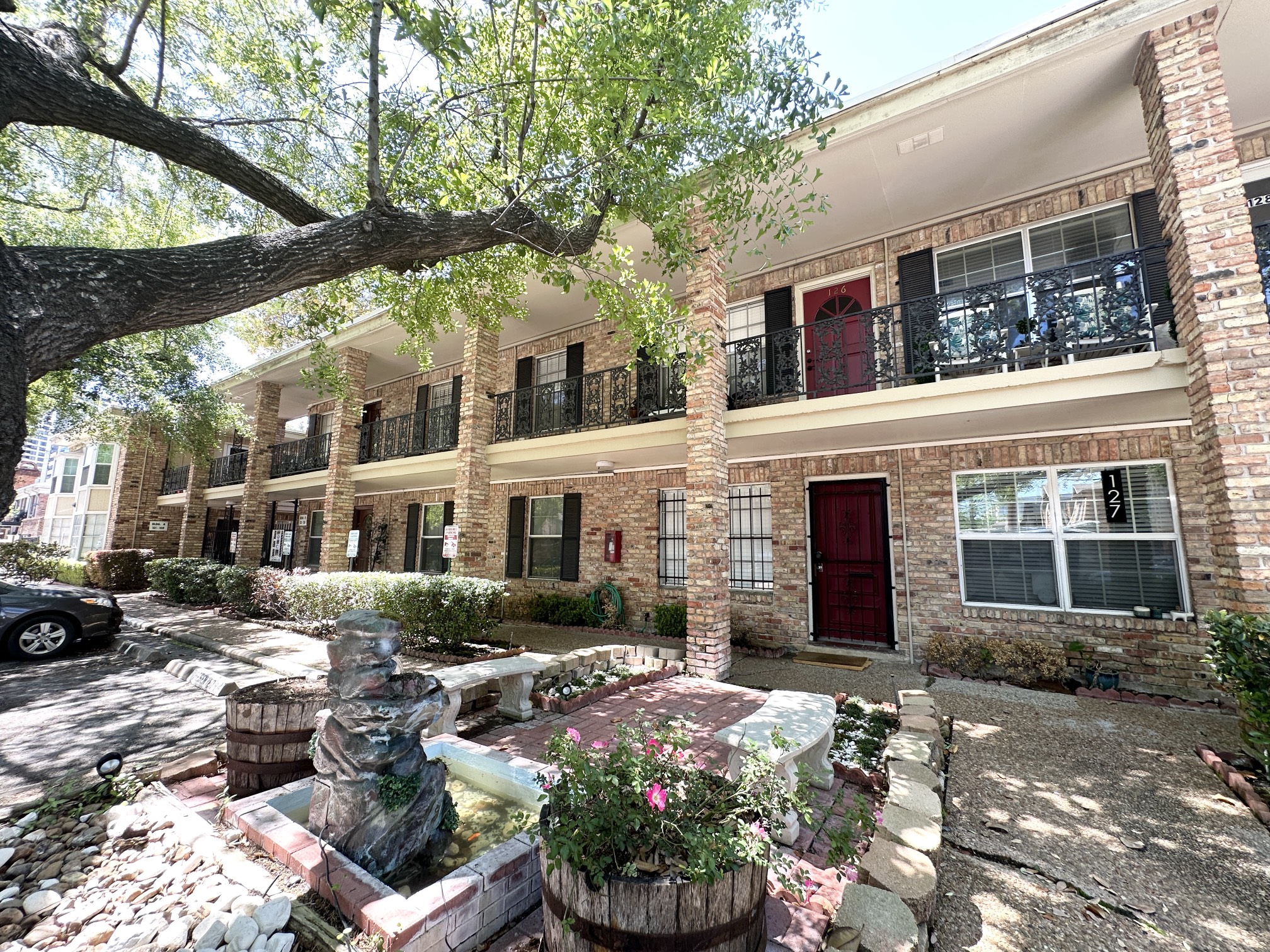 3224 Timmons Lane, Unit 154 Houston, TX 77027 - Photo 21 of 21 a front view of a house with a yard and a fountain