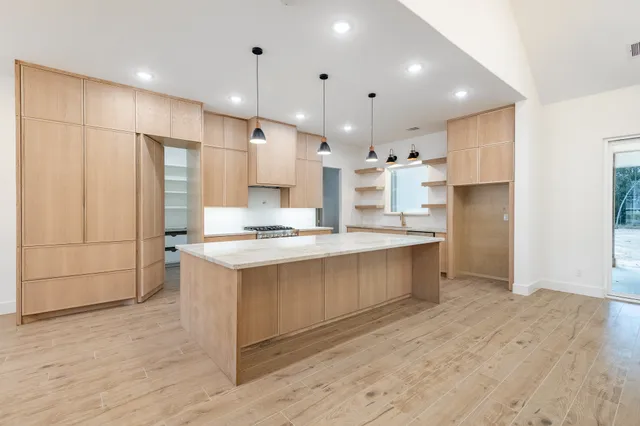a large kitchen with kitchen island a sink stainless steel appliances and cabinets