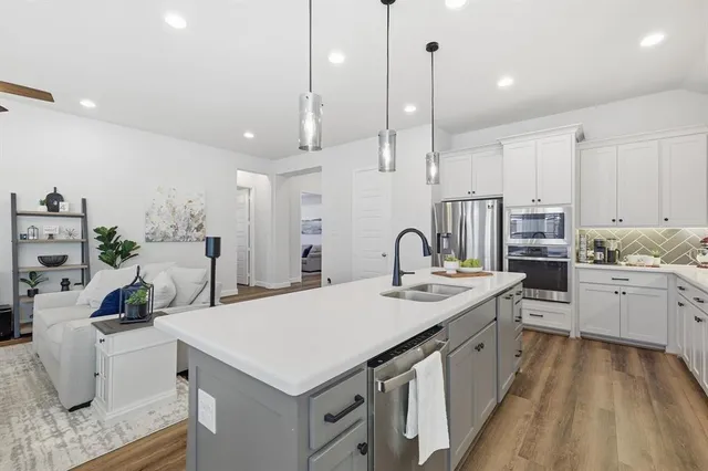 a kitchen with stainless steel appliances kitchen island hardwood floor sink and stove