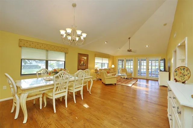 a view of a dining room with furniture a chandelier and wooden floor