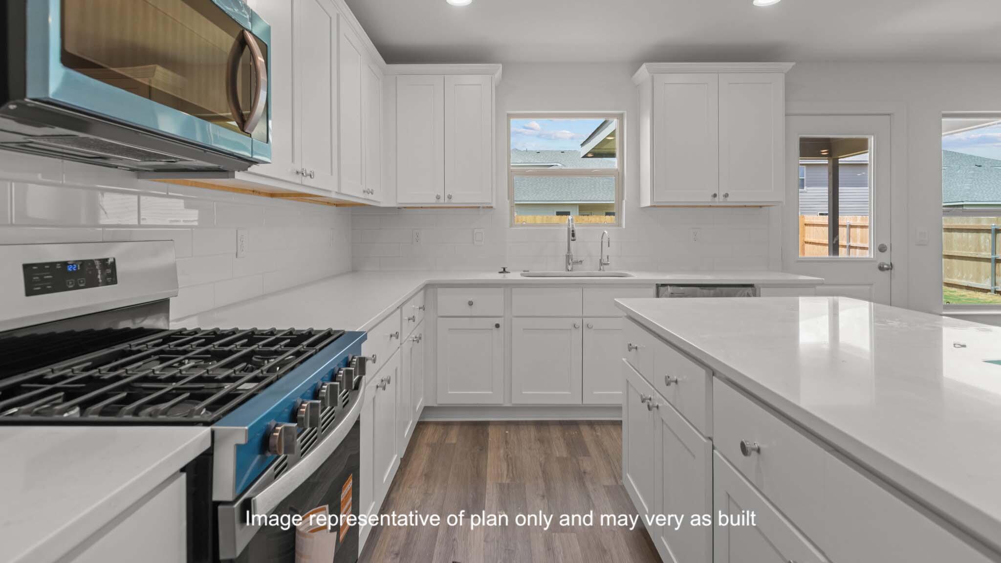 7443 9th Street Lubbock, TX 79416 - Photo 12 of 28 a kitchen with granite countertop a stove sink and cabinets