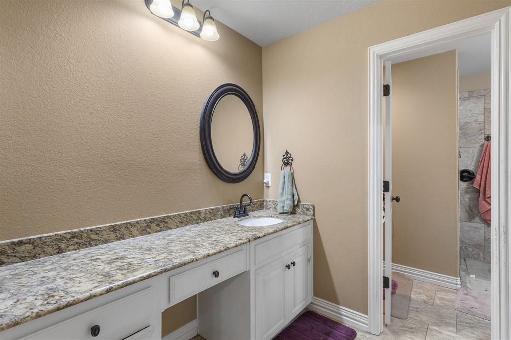 4504 Jennings Avenue Wichita Falls, TX 76310 - Photo 16 of 26 a bathroom with a granite countertop sink a mirror and a shower