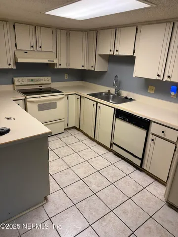 a kitchen with a sink a stove and cabinets