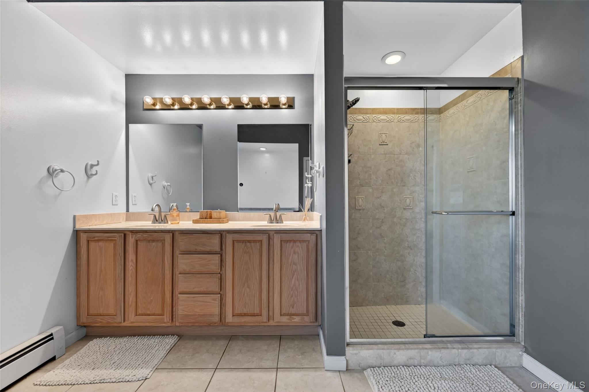 19 Bull Mine Road Chester, NY 10918 - Photo 24 of 42 Double vanity with wood cabinetry and dual mirrors, complemented by a large glass-enclosed shower featuring tile surround and recessed lighting