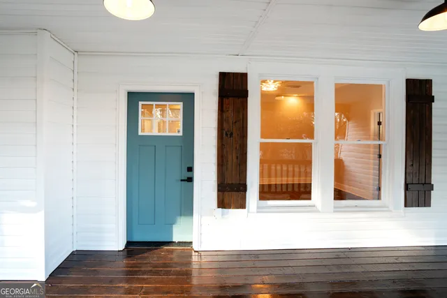 an empty room with wooden floor and a ceiling fan