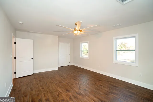a view of a hallway with wooden floor and a living room