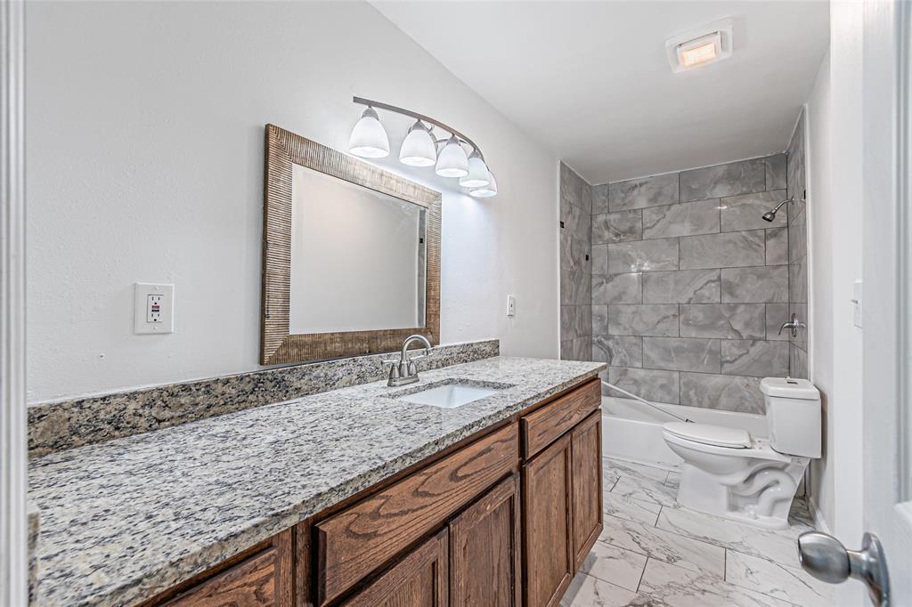605 Lloyd Italy, TX 76651 - Photo 11 of 30 a bathroom with a granite countertop sink a toilet and bathtub