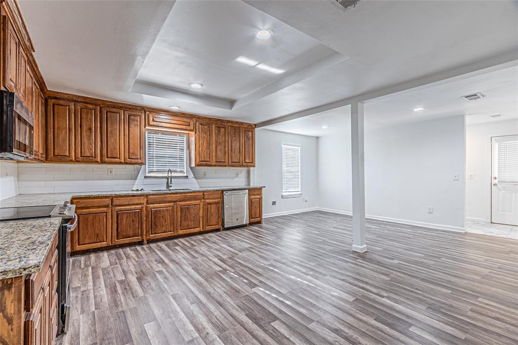 605 Lloyd Italy, TX 76651 - Photo 14 of 30 a large kitchen with wooden floors and wooden cabinets