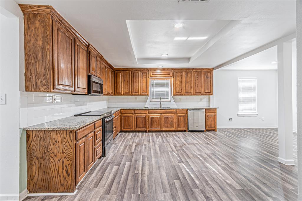 605 Lloyd Italy, TX 76651 - Photo 15 of 30 a kitchen with wooden floors and wooden cabinets