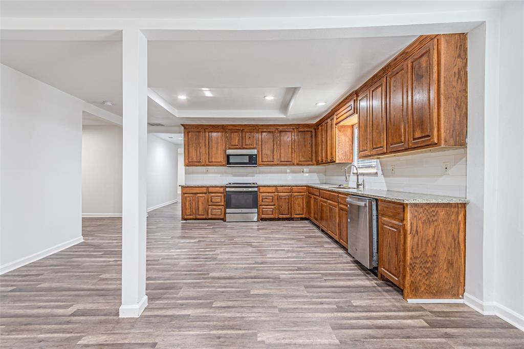 605 Lloyd Italy, TX 76651 - Photo 16 of 30 a large kitchen with wooden floors stainless steel appliances and cabinets