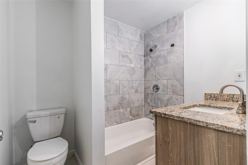 605 Lloyd Italy, TX 76651 - Photo 8 of 30 a bathroom with a granite countertop bathtub shower sink mirror and toilet