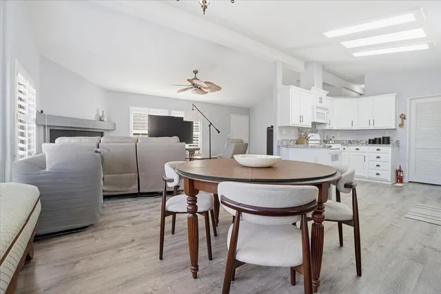 a kitchen with stainless steel appliances a table chairs and microwave