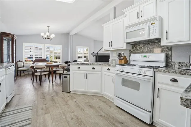 a kitchen with white cabinets and white appliances
