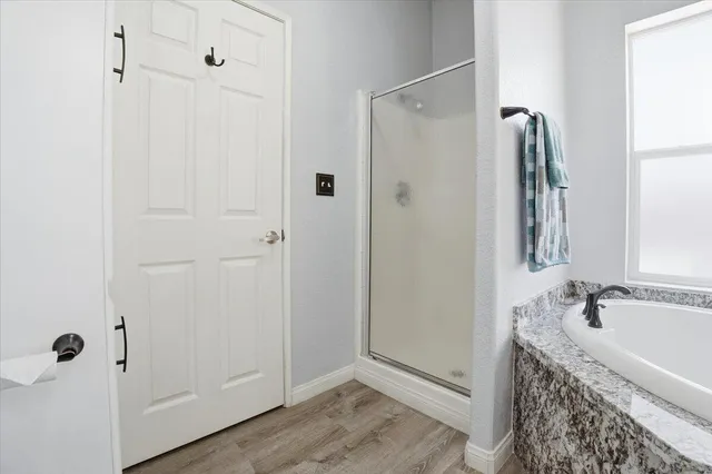 a bathroom with a granite countertop sink a mirror and shower