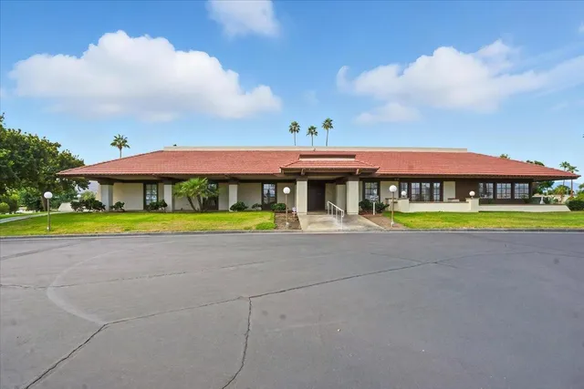a view of a swimming pool with lawn chairs with plants and lake view