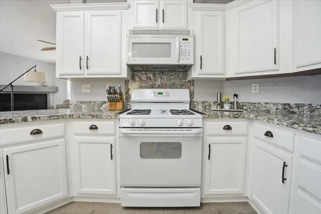 a kitchen with white cabinets and white appliances