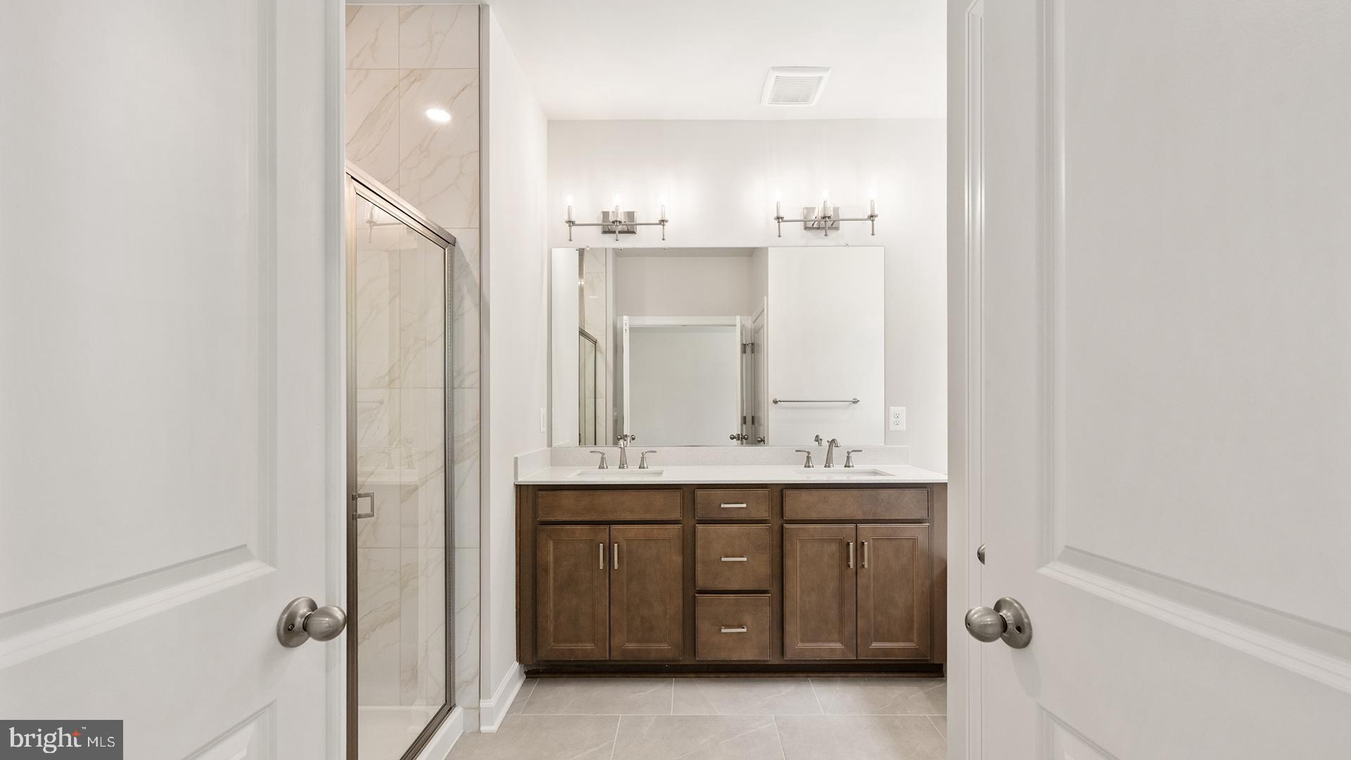 14018 Northern Vw Road Culpeper, VA 22701 - Photo 11 of 27 a bathroom with a double vanity sink a mirror and a bathtub