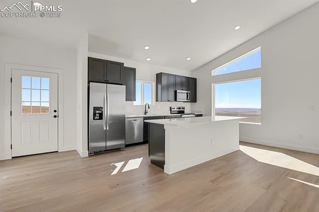 a view of kitchen with stainless steel appliances kitchen island a refrigerator sink and cabinets