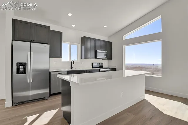 a kitchen with stainless steel appliances a refrigerator sink and microwave