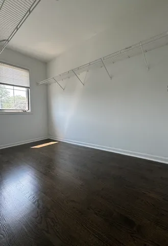 an empty room with wooden floor and windows in it