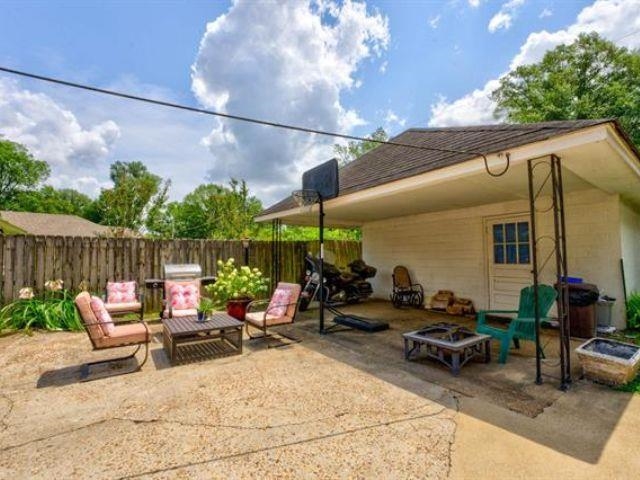 1694 South White Station Road Memphis, TN 38117 - Photo 24 of 26 The fenced backyard offers room to relax, garden, or play. Enjoy a covered patio for outdoor living and a powered workshop with window AC — ideal for hobbies, storage, or projects. The double gate makes vehicle access easy.