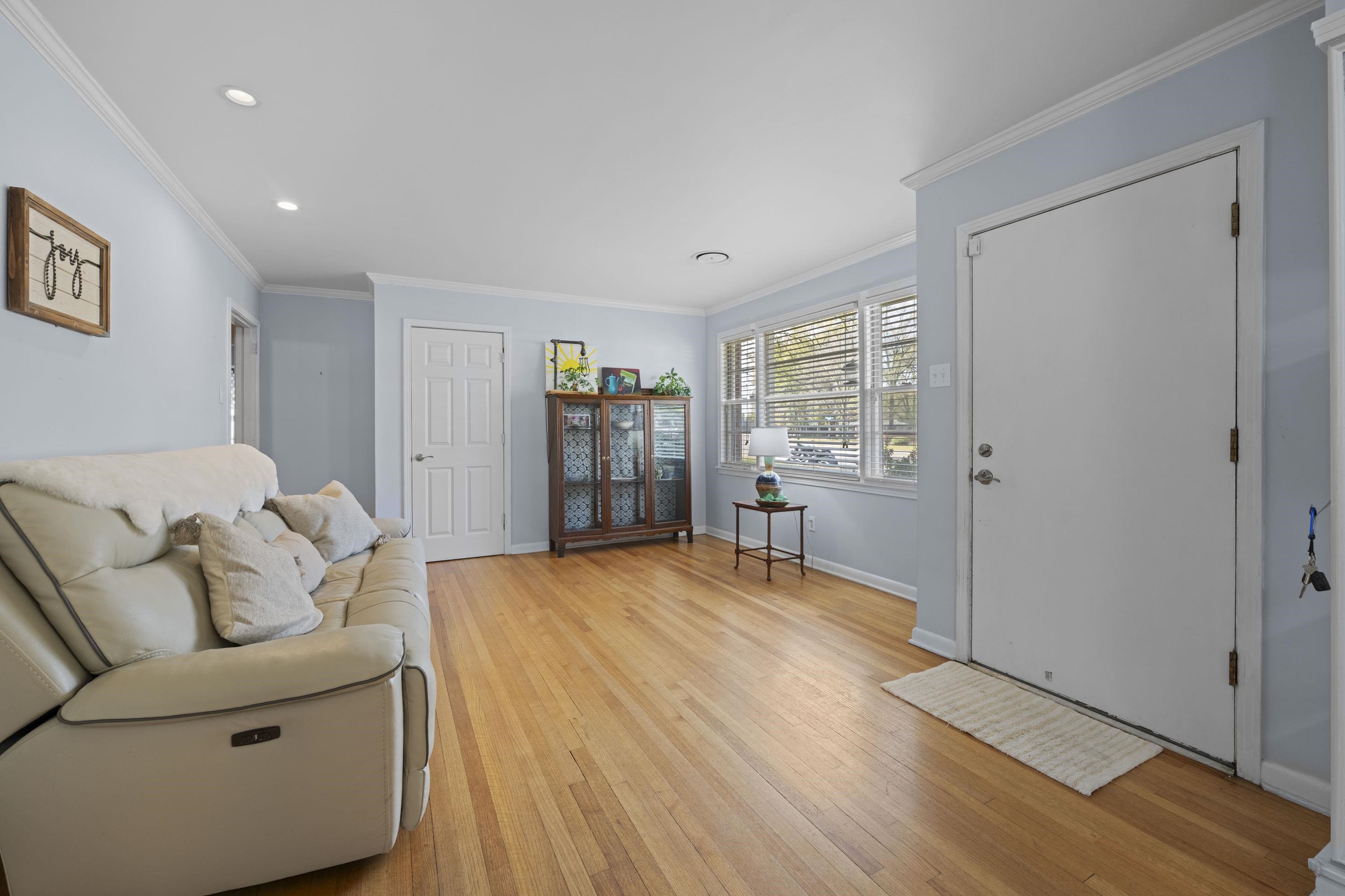 1694 South White Station Road Memphis, TN 38117 - Photo 4 of 26 This living room offers a warm, inviting feel the moment you walk in. Natural light fills the space, highlighting the beautiful original hardwood floors and creating the perfect spot for relaxing, gathering, or enjoying a quiet moment at home.