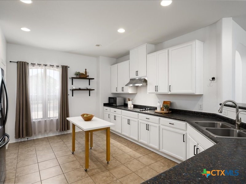 18817 Star Gazer Way Pflugerville, TX 78660 - Photo 16 of 36 a kitchen with stainless steel appliances granite countertop a refrigerator sink and white cabinets
