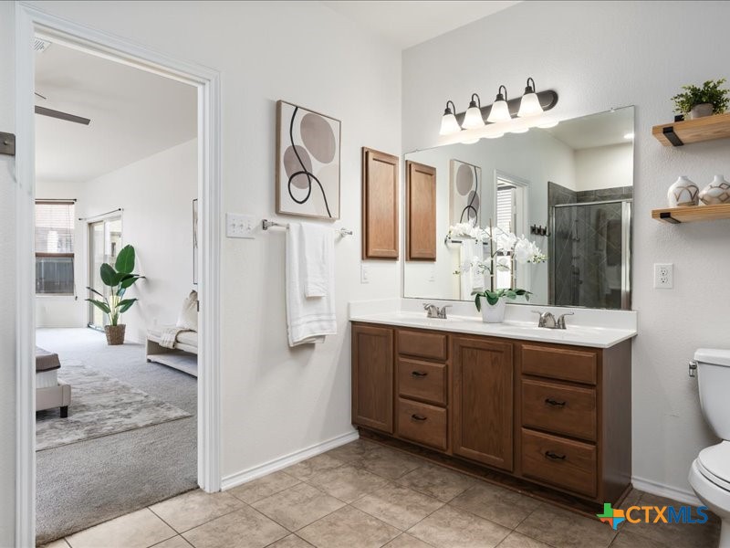 18817 Star Gazer Way Pflugerville, TX 78660 - Photo 22 of 36 a spacious bathroom with a double vanity sink a toilet a mirror and shower