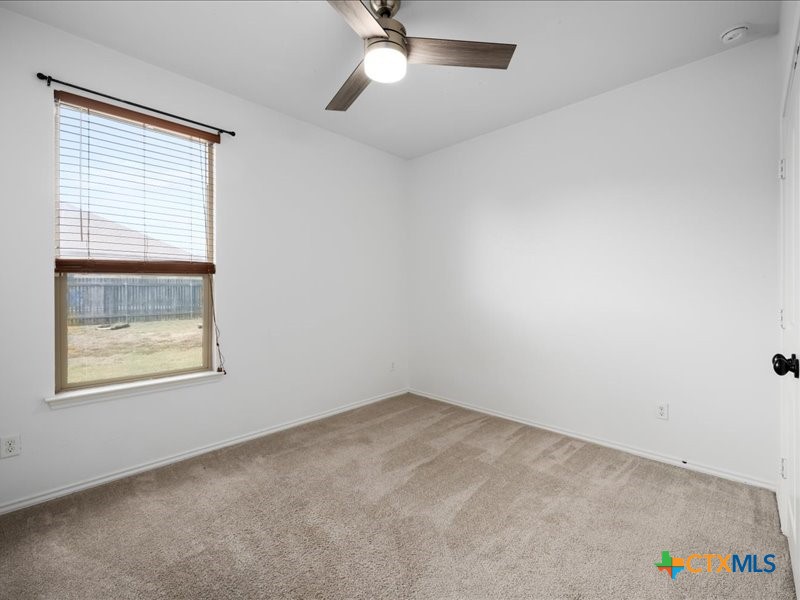 18817 Star Gazer Way Pflugerville, TX 78660 - Photo 25 of 36 an empty room with a window and a ceiling fan