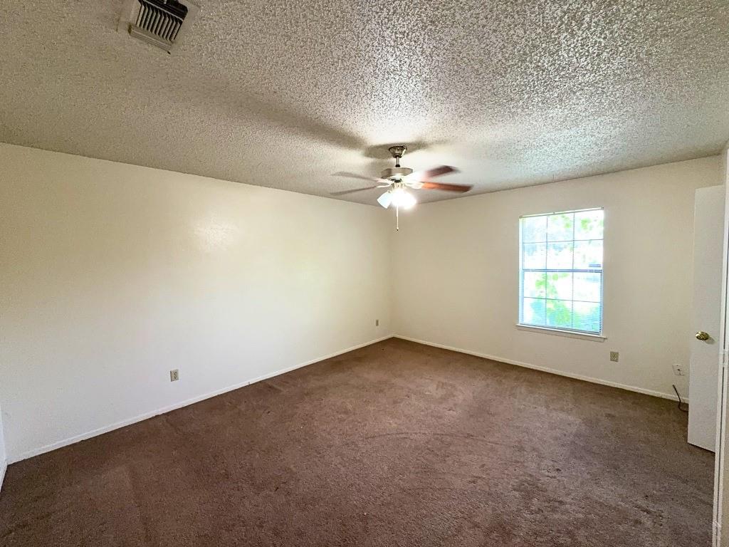 1613 Edgehill Road Benbrook, TX 76126 - Photo 8 of 22 an empty room with a chandelier fan and windows