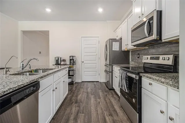 a kitchen with stainless steel appliances granite countertop a kitchen island hardwood floor sink stove and granite counter top
